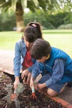 Deux enfants jardinent dehors au Portugal, en train de creuser la terre dans un jardin verdoyant